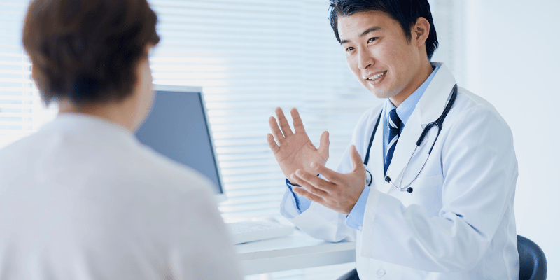 医師と患者が診察室で会話している様子。医師のアドバイスを受けるシーン